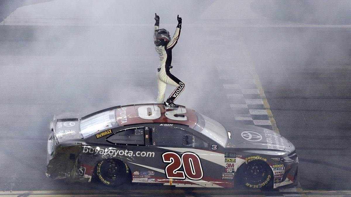 Erik Jones celebrates in front of fans after winning the NASCAR Cup Series auto race at Daytona International Speedway, Saturday, July 7, 2018, in Daytona Beach, Fla. (AP Photo/Terry Renna)