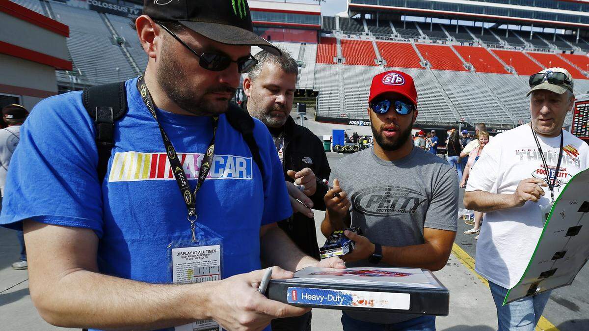 Driver Bubba Wallace signs autographs before practice for a NASCAR Cup series auto race, Friday, April 13, 2018 in Bristol, Tenn. (AP Photo/Wade Payne)