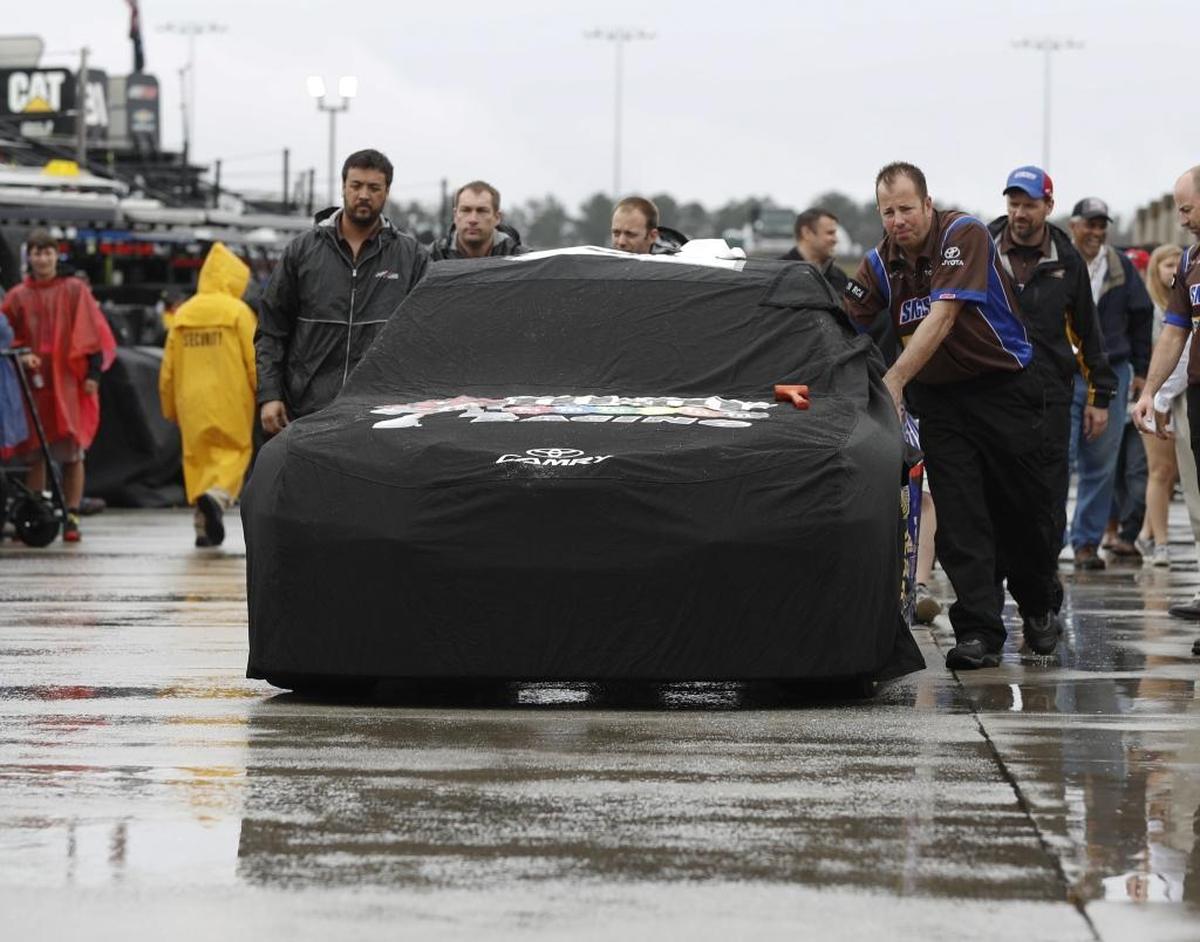 Rain delayed the start of Sunday’s NASCAR Cup Series race at Atlanta Motor Speedway by 2 hours, 30 minutes. Then, the threat of more rain added urgency in the late battle for the lead. Above, crew members cover and push Kyle Busch's No. 18 car toward the garage.