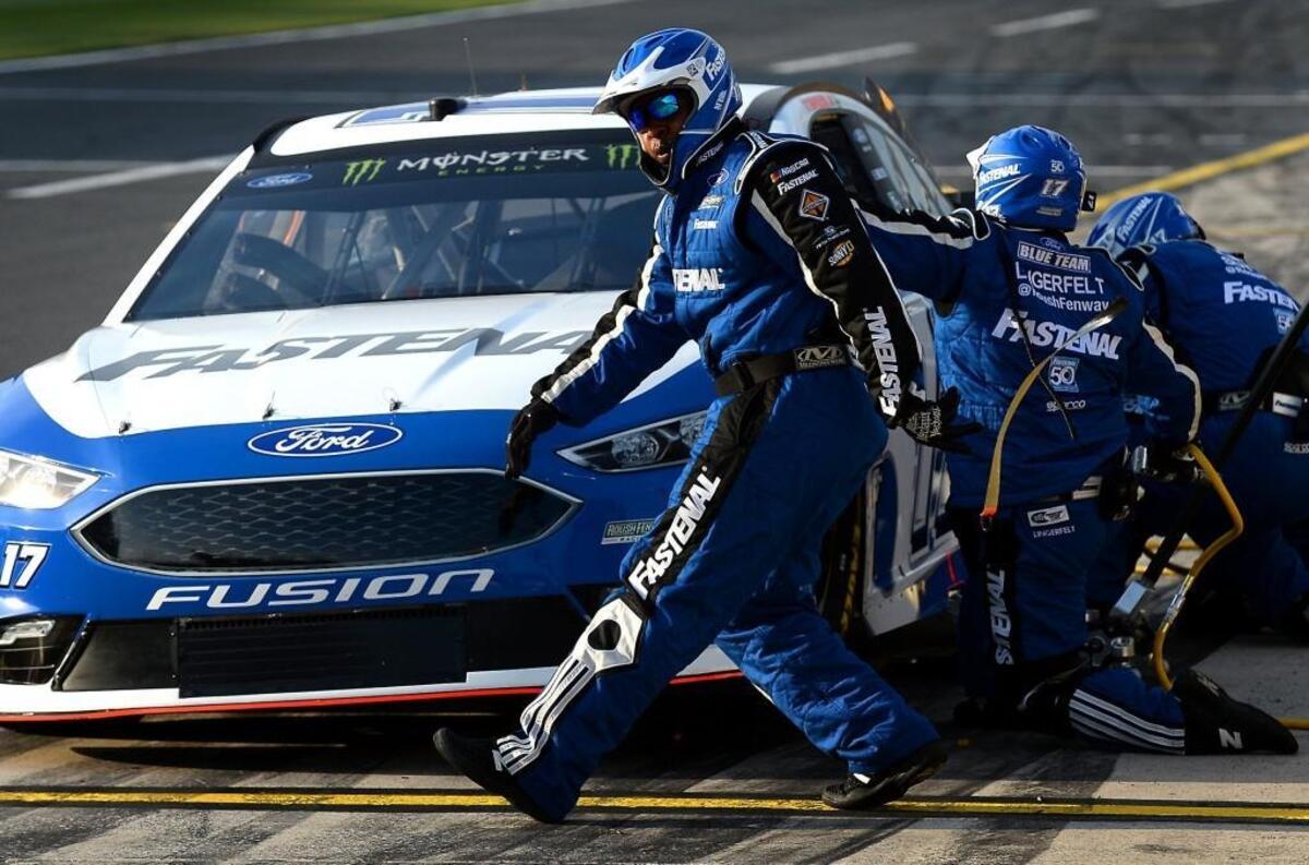 NASCAR tire carrier Kevin Richardson rips a piece of tape from the front of the car during the NASCAR All-Star Race qualifying at Charlotte Motor Speedway on Friday. Richardson, a former football player at Appalachian State, works for driver Ricky Stenhouse Jr.'s team.