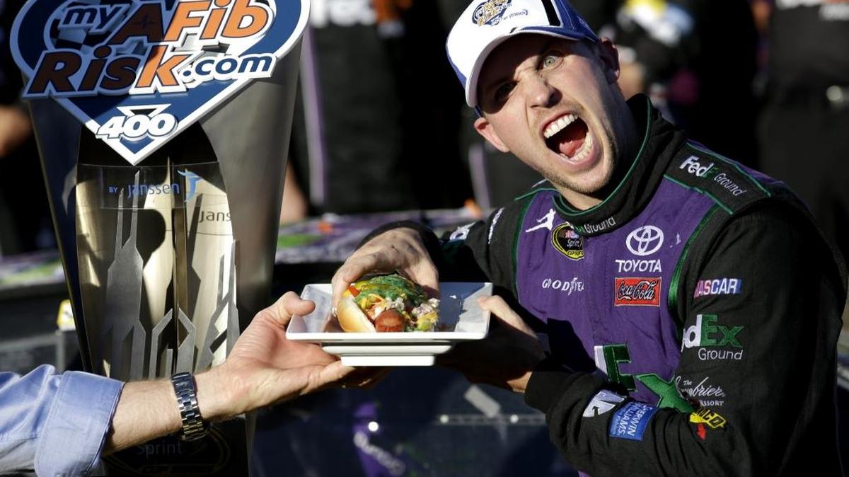 
Denny Hamlin prepares to eat a Chicago style hot dog in Victory Lane after winning the NASCAR Sprint Cup Series auto race at Chicagoland Speedway, Sunday in Joliet, Ill. 
