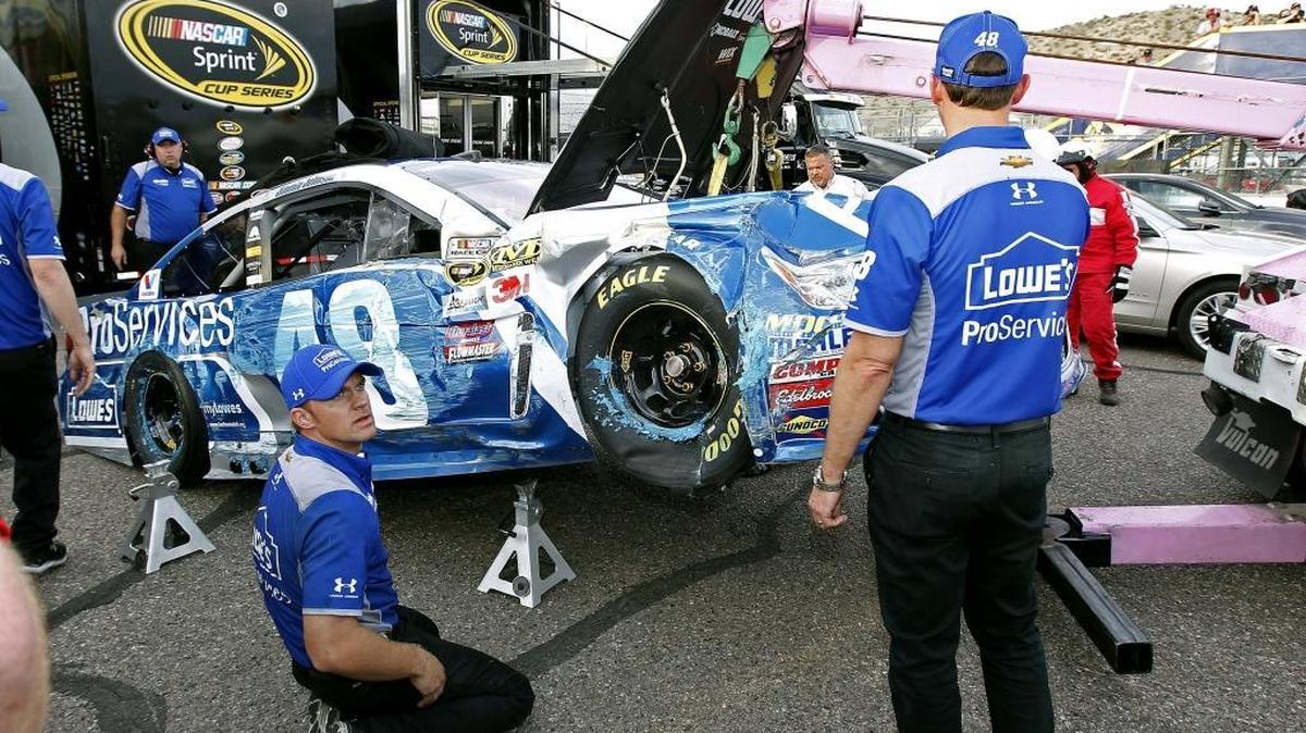 Jimmie Johnson’s pit crew works on the No. 48 Chevy after Johnson crashed during qualifying Friday at Phoenix International Raceway.