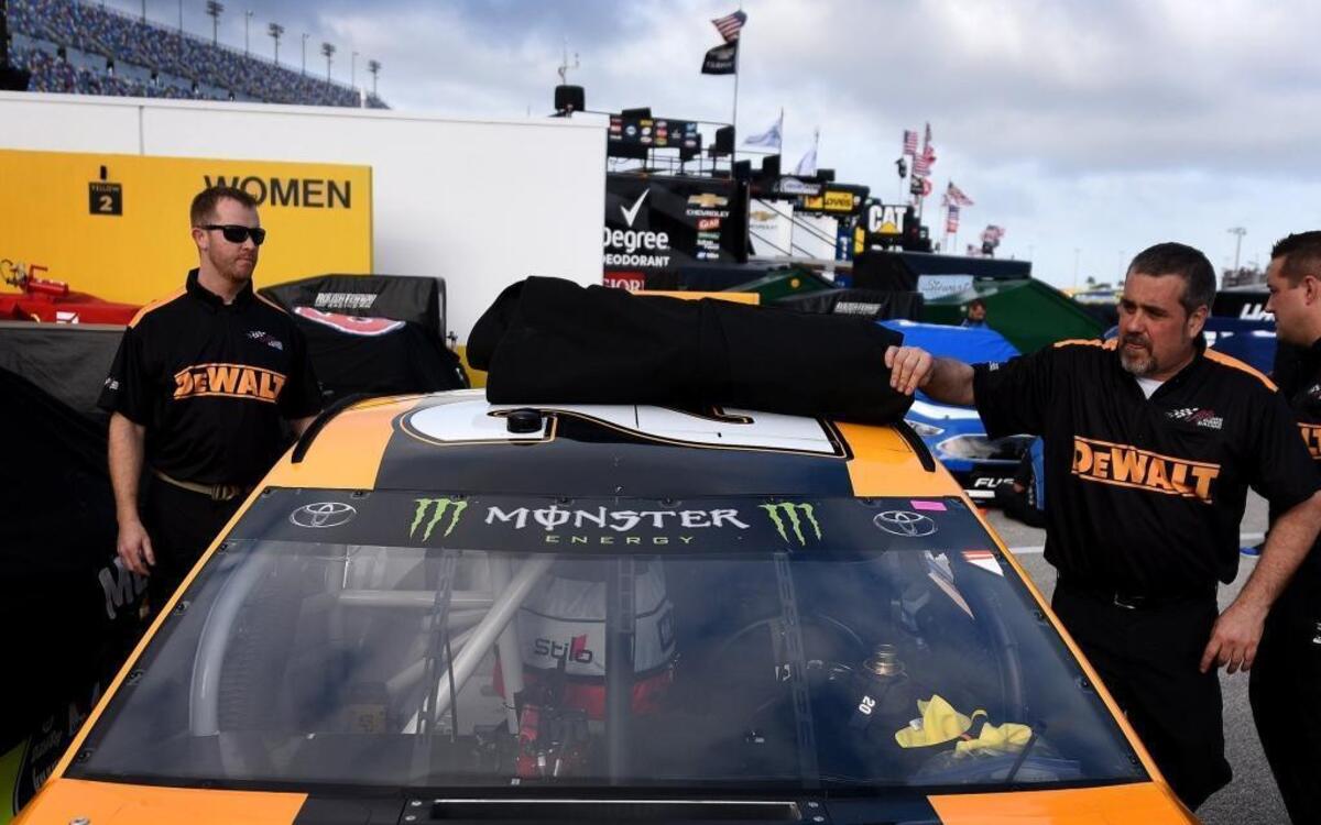 Crewmen for NASCAR driver Matt Kenseth cover the car in the garage area of Daytona International Speedway on Thursday. Each Cup Series car carries the Monster Energy logo on the front windshield this season. Monster Energy is NASCAR’s new top-series title sponsor this season.