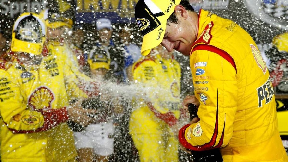 
Joey Logano, driver of the No. 22 Shell Pennzoil Ford, celebrates with champagne in Victory Lane after winning the NASCAR Sprint Cup Series Irwin Tools Night Race at Bristol Motor Speedway on Aug. 23, 2014 in Bristol, Tenn.
