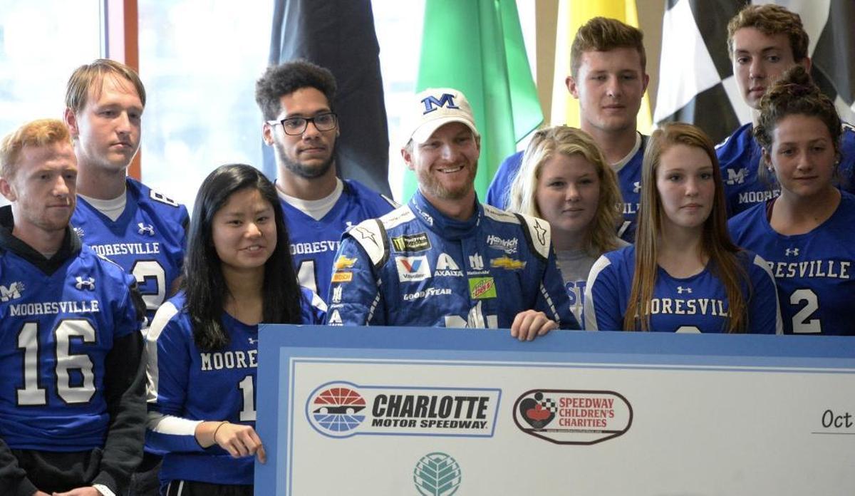 Monster Energy NASCAR Cup Series driver Dale Earnhardt Jr. (88) stands with athletes from Mooresville High during a press conference at Charlotte Motor Speedway on Friday, October 6, 2017. Charlotte Motor Speedway and Speedway Children's Charities have established the Sale Earnhardt, Jr. Concussion Research Fund at Carolinas Healthcare System's Levine Children's Hospital with a $100,000 gift.