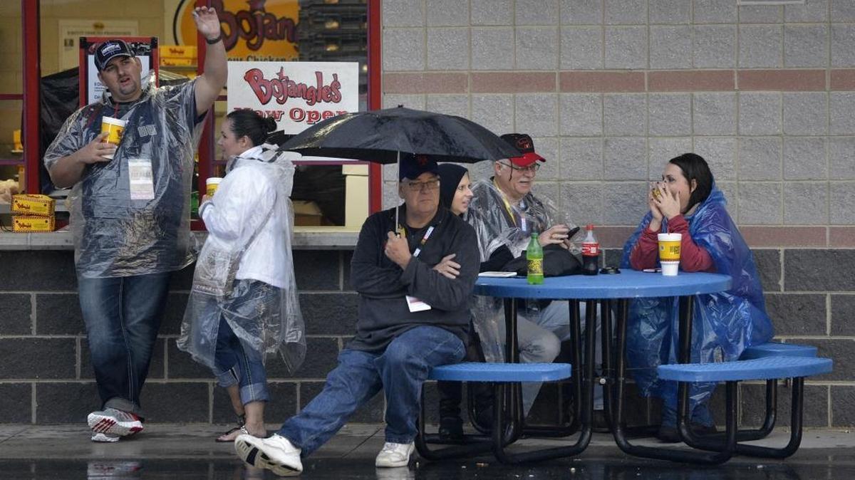 
Fans brave the rain before the NASCAR Sprint Cup Bank of America 500 at Charlotte Motor Speedway was postponed due to rain Saturday, October 10, 2015. 
