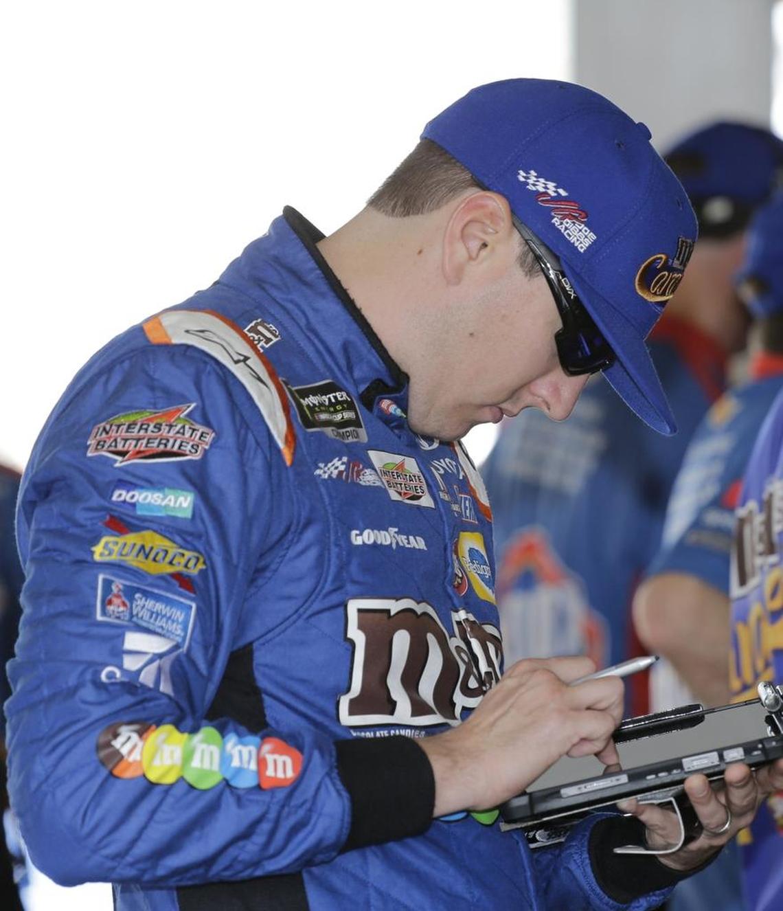 Kyle Busch checks a monitor before practice for Sunday’s NASCAR race at Homestead-Miami Speedway in Homestead, Fla.