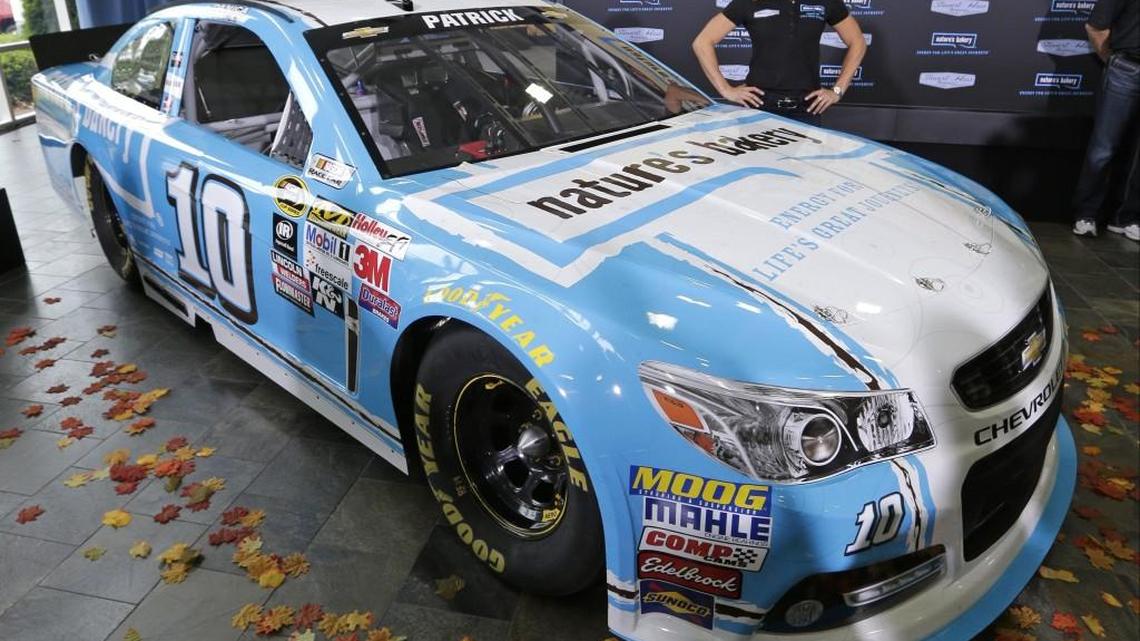 
Danica Patrick poses by her new race car during a news conference to announce a new sponsorship for her NASCAR auto racing team at Stewart-Haas Racing's headquarters in Kannapolis, N.C., Tuesday, Aug. 18, 2015. (AP Photo/Chuck Burton) 
