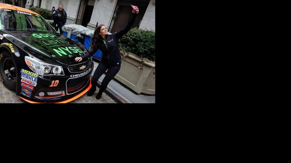 
Race car driver Danica Patrick takes a selfie with her car in front of the New York Stock Exchange, before the GoDaddy IPO on Wednesday. Patrick’s contract with sponsor GoDaddy expires after this NASCAR Sprint Cup season. 
