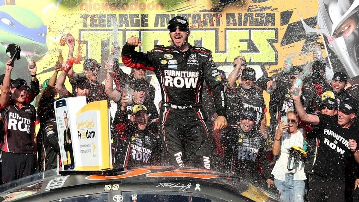 Martin Truex Jr, driver of the No. 78 Furniture Row Toyota, celebrates in Victory Lane after winning the NASCAR Sprint Cup Series Teenage Mutant Ninja Turtles 400 at Chicagoland Speedway on Sunday. Postrace inspection showed problems with his car, and the team says it will accept NASCAR’s punishment.