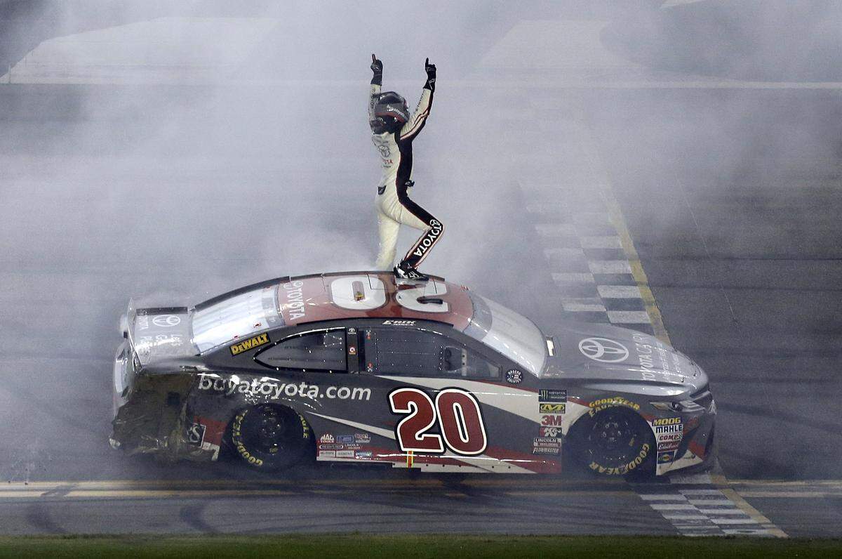Erik Jones celebrates in front of fans after winning the NASCAR Cup Series auto race at Daytona International Speedway, Saturday, July 7, 2018, in Daytona Beach, Fla. (AP Photo/Terry Renna)