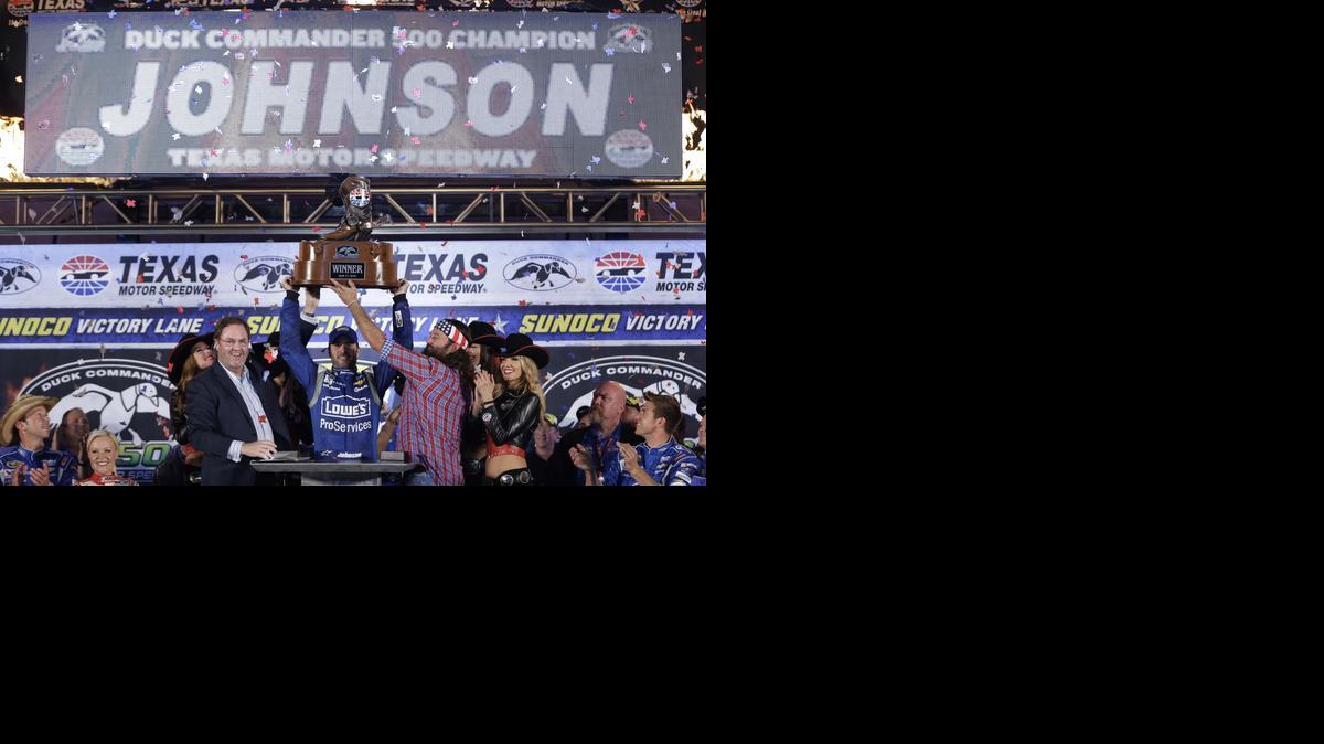 
Jimmie Johnson holds up the winner's trophy with the help of Eddie Gossage and Willie Robertson after Johnson won the NASCAR Sprint Cup Series auto race at Texas Motor Speedway in Fort Worth, Texas, on Saturday. After a poor finish at Martinsville and a week off, Johnson said his team had benefitted from the “reboot.”
