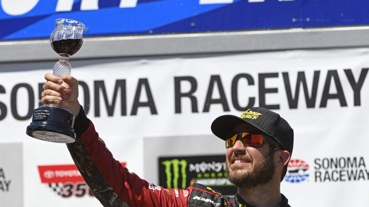 NASCAR driver Martin Truex Jr. (78) raises the Champion's Goblet as he celebrates in the winner's circle after winning the Toyota/Save Mart 350 at Sonoma Raceway in Sonoma, Calif., on Sunday, June 24, 2018. (Jose Carlos Fajardo/Bay Area News Group/TNS)