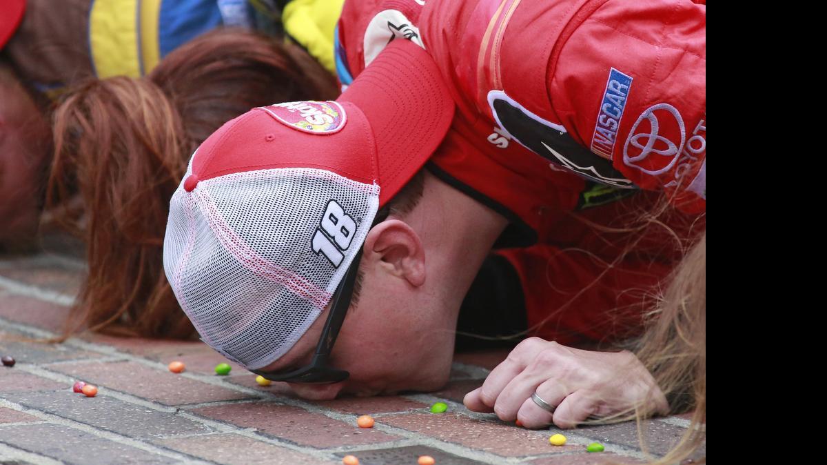 
Kyle Busch kisses the bricks on the start/finish line after winning the NASCAR Brickyard 400 auto race at Indianapolis Motor Speedway in Indianapolis, Sunday, July 26, 2015.
