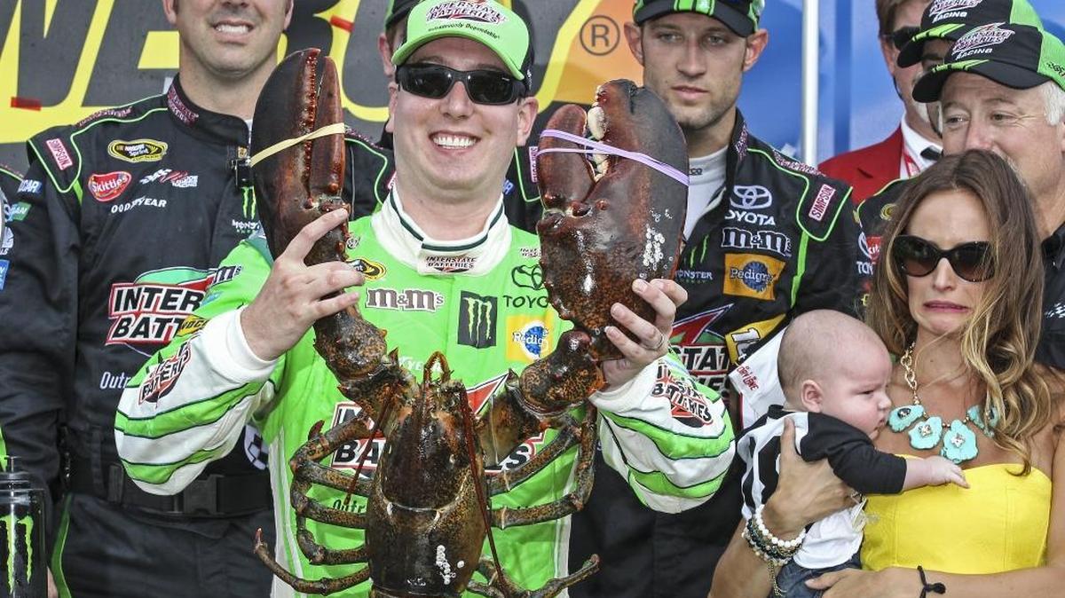 Kyle Busch holds the Loudon lobster trophy in Victory Lane, as his wife, right, Samantha holding son Brexton looks on, after winning at New Hampshire Motor Speedway on July 19, 2015.