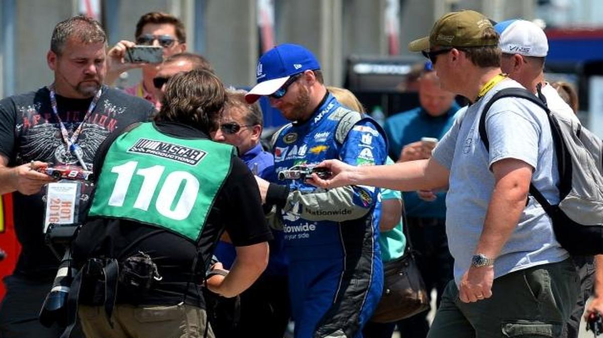 NASCAR Sprint Cup Series driver Dale Earnhardt Jr., center, is surrounded by fans as he walks to the garage signing autographs before Thursday’s practice at Charlotte Motor Speedway.