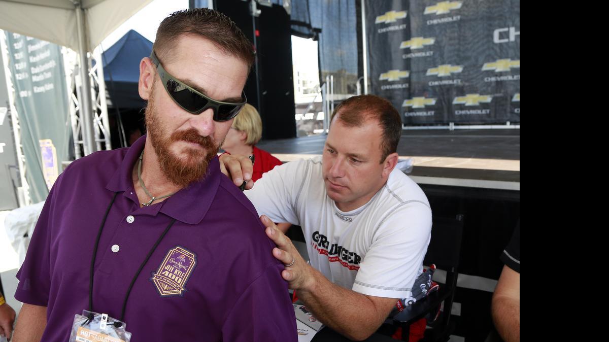 
Jeff Kyle has his shirt signed by Sprint Cup Series driver Ryan Newman (31) following practice for the NASCAR Brickyard 400 auto race at Indianapolis Motor Speedway. The brother of famed "American Sniper" Chris Kyle will be honored this weekend at the NASCAR race at Indianapolis Motor Speedway. 
