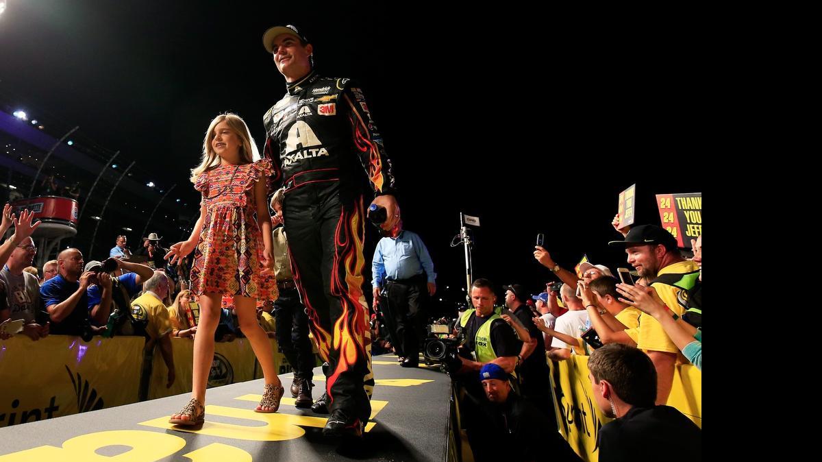 
Jeff Gordon walks across the stage with his daughter, Ella, during driver introductions before the NASCAR Sprint All-Star Race.
