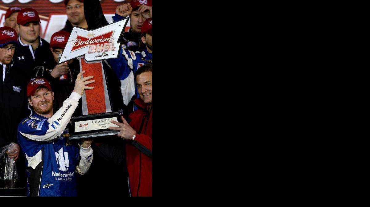 
NASCAR Sprint Cup Series driver Dale Earnhardt Jr.lifts a Budweiser Duel trophy into the air as he and his team celebrate their victory in the first of two Duel 150-mile qualifying races for the Daytona 500 at Daytona International Speedway on Thursday.

