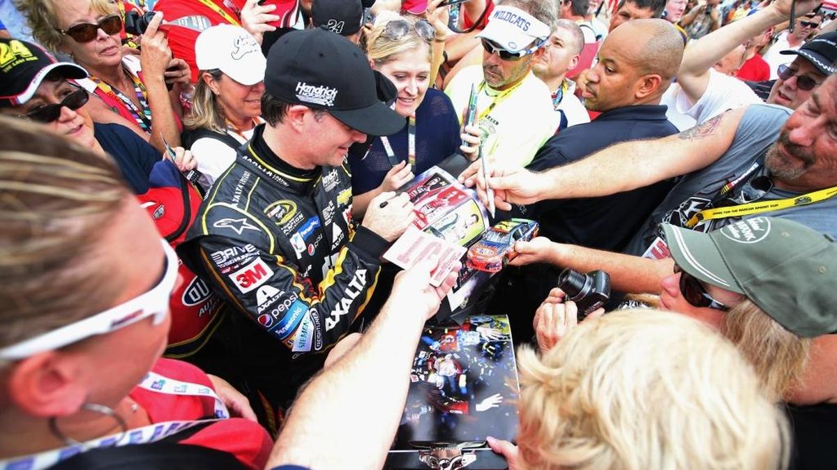 Jeff Gordon signs autographs for fans during Saturday’s practice for the NASCAR Sprint Cup Series Ford EcoBoost 400 at Homestead-Miami Speedway. The highest finisher among the four Chase finalists - Kyle Busch, Gordon, Kevin Harvick and Martin Truex Jr. - wins this season’s Cup championship.