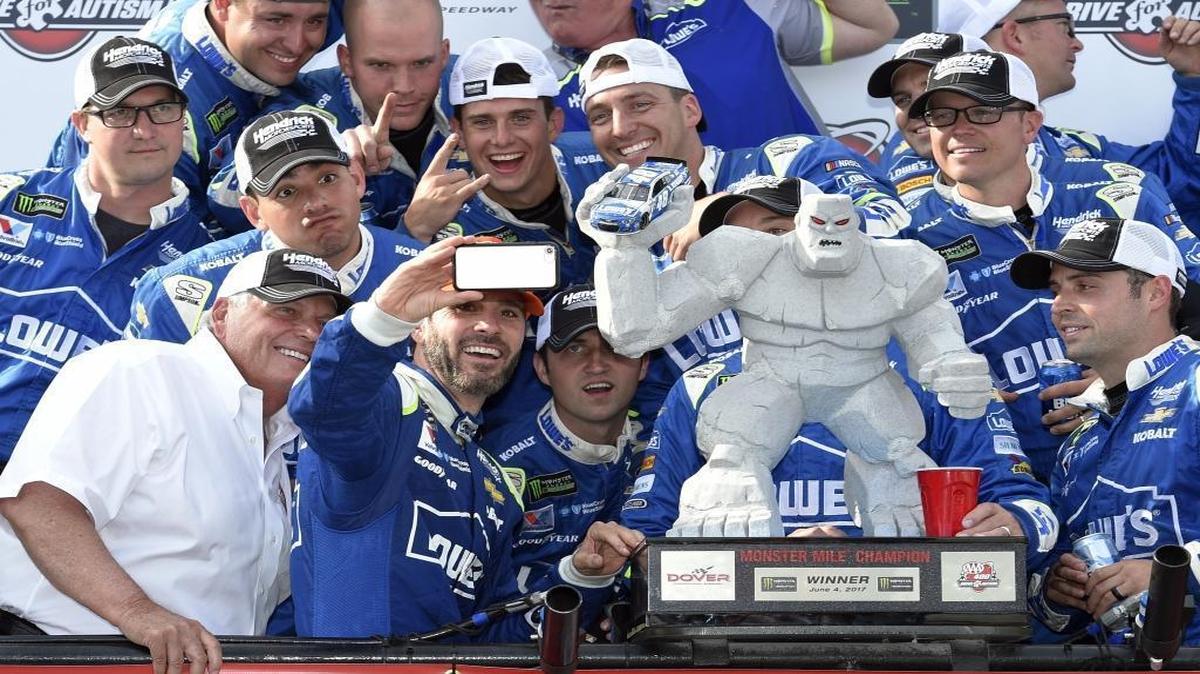 Jimmie Johnson, second from front left, takes a photo in Victory Lane after winning Sunday’s NASCAR Cup series auto race at Dover International Speedway in Dover, Del.
