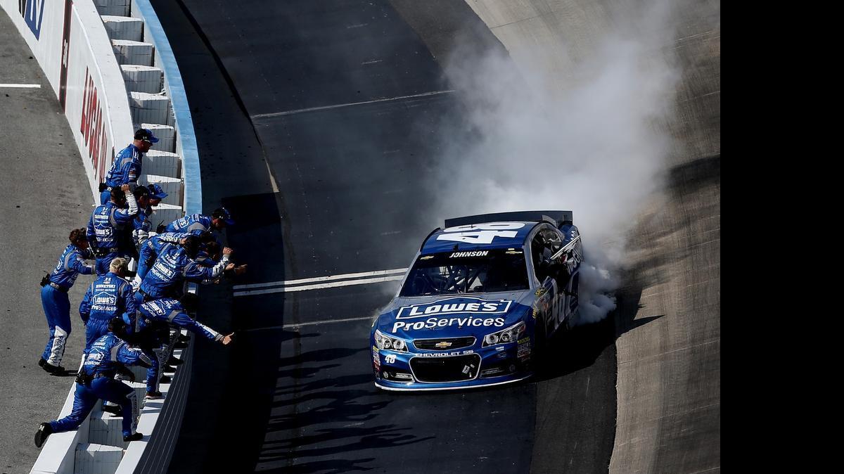 
Jimmie Johnson is cheered by his team while celebrating with a burnout after winning the NASCAR Sprint Cup Series FedEx 400 Benefiting Autism Speaks at Dover International Speedway on Sunday, May 31, 2015 in Dover, Del.
