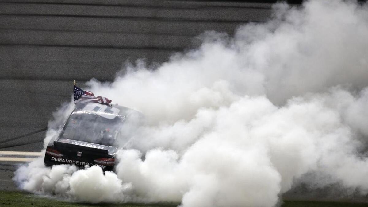 Brad Keselowski smokes his tires after winning Saturday’s Coke Zero 400 at Daytona International Speedway.