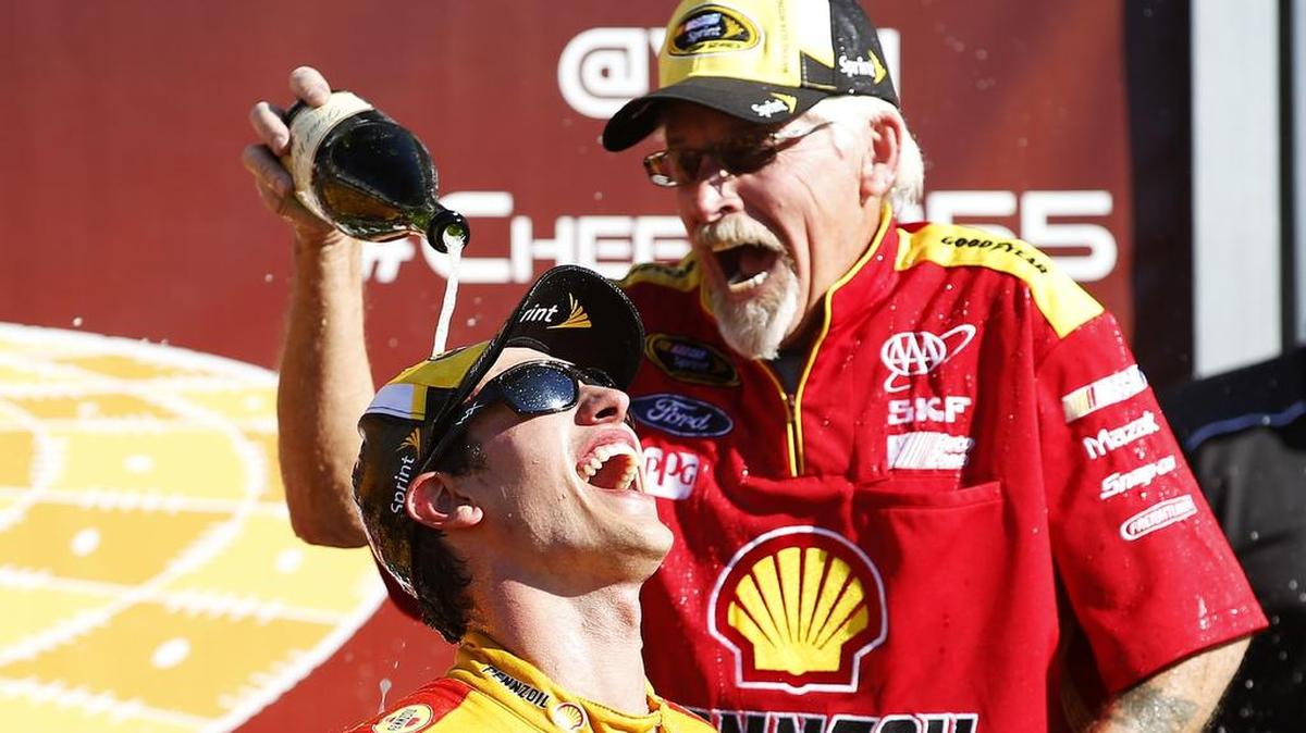 
Joey Logano and a crew member celebrate with champagne after winning the NASCAR Sprint Cup Series Cheez-It 355 at the Glen at Watkins Glen International on Sunday, Aug. 9, 2015 in Watkins Glen, N.Y.
