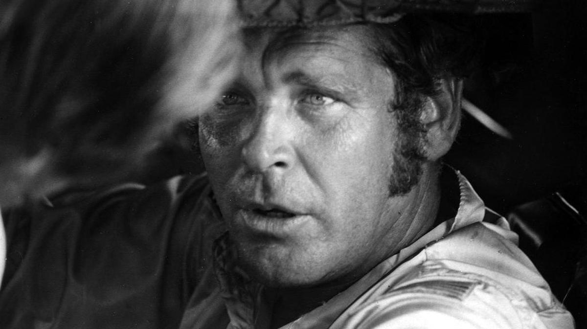 
Buddy Baker talks about the Ford he is driving with his crew chief in this May, 1974 photo.
