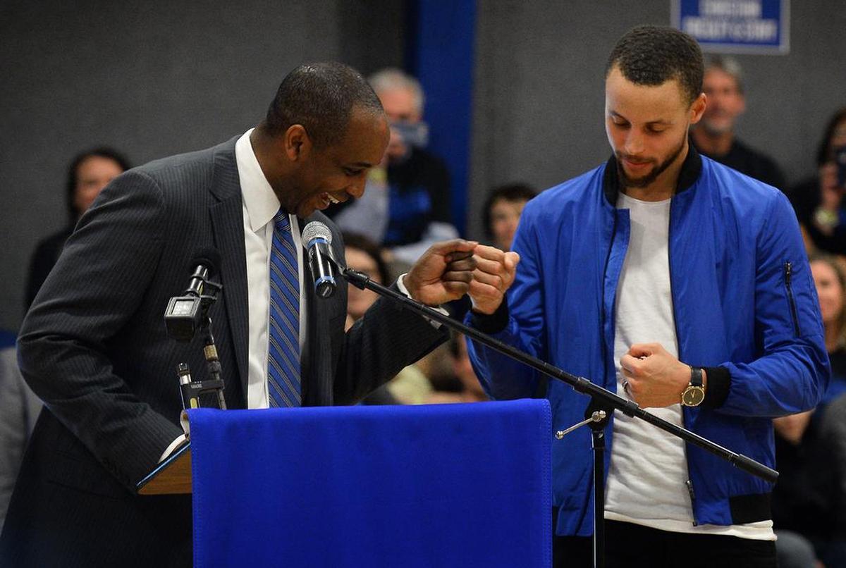 NBA star Steph Curry, right, bumps fists with his high school basketball coach Shonn Brown, left, on Tuesday, January 24, 2017. Curry returned to Charlotte Christian School for the retirement of his high school #20 jersey.