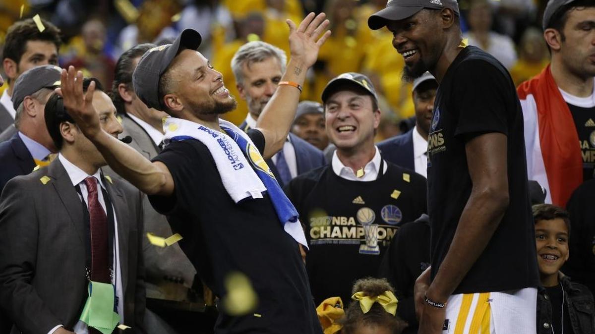 The Golden State Warriors' Stephen Curry, left, celebrates with teammate Kevin Durant after defeating the Cleveland Cavaliers, 129-120, in Game 5 of the NBA Finals. Curry said Wednesday he will not visit the White House if invited