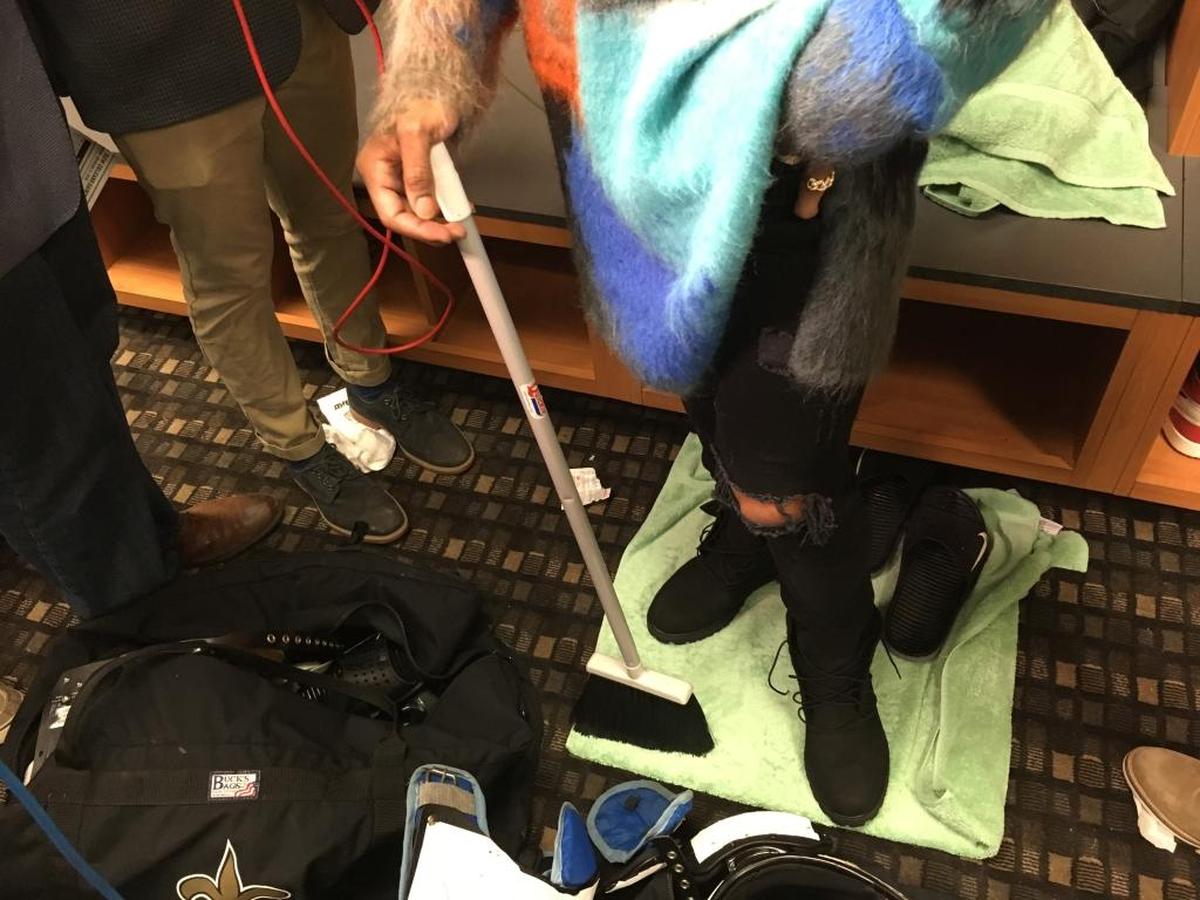 New Orleans Saints wide receiver Ted Ginn Jr. holds a broom while speaking after his team’s 31-26 win in Sunday’s wild-card playoff game at the Superdome.