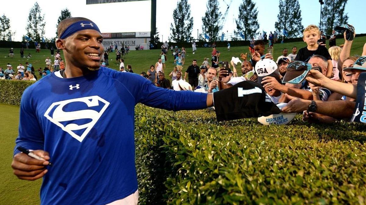Carolina Panthers quarterback Cam Newton smiles as he stops to sign an autograph for a fan following practice on Thursday at Wofford College in Spartanburg, SC.