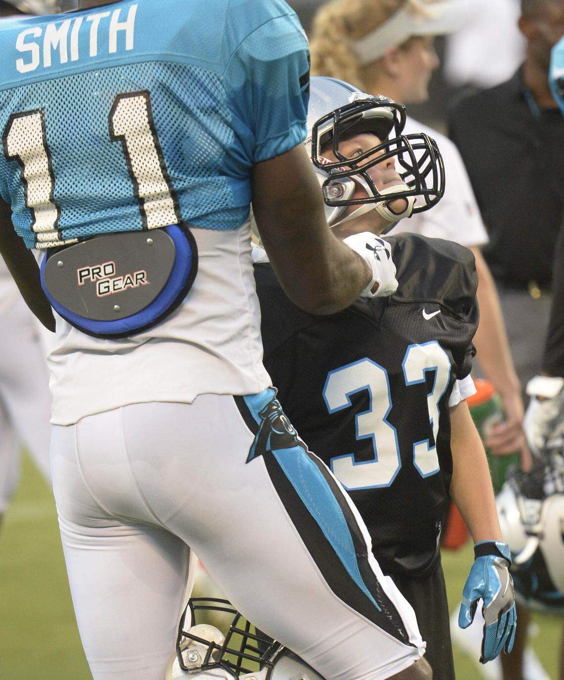 Korben Senden gets help with his uniform from Carolina Panthers wide receiver Torrey Smith (11) during practice at the Carolina Panthers’ Fan Fest at Bank of America Stadium on Friday, August 3, 2018.  The team, in partnership with Make-A-Wish, granted Korben’s wish “to be a Carolina Panther.” Senden is 13 year old, from Eagle Ridge, Alaska.