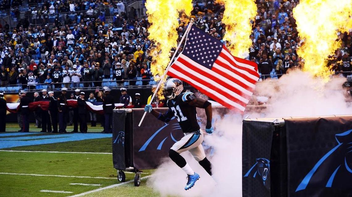 Carolina Panthers' Charles Tillman (31) carries a US flag as he is introduced prior to playing the Green Bay Packers at Bank of America Stadium on Sunday, November 8, 2015. Tillman announced his retirement Monday after 13 NFL seasons.