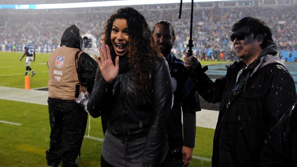 Jordin Sparks', center, smiles and waves to passerby after singing the National Anthem at Bank of America Stadium before Monday night’s game.