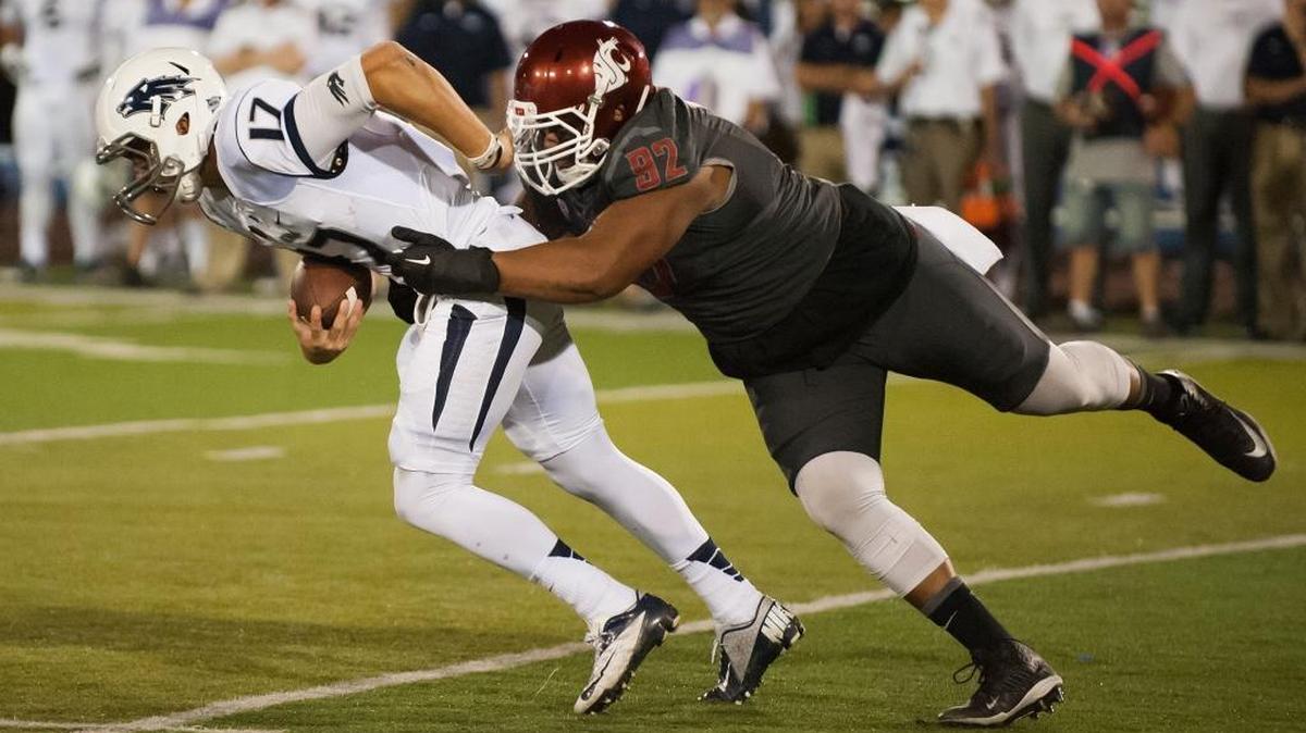 Nevada’s Cody Fajardo, left, is sacked by Washington State’s Robert Barber during the 2014 season. A source said the the Carolina Panthers have rescinded a undrafted free-agent offer to Barber, a defensive tackle.