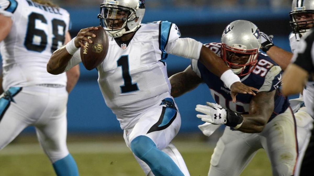
Carolina Panthers' Cam Newton (1) tries to avoid being sacked by New England Patriots' Dominique Easley (99) during their preseason game at Bank of America Stadium on August 28, 2015.
