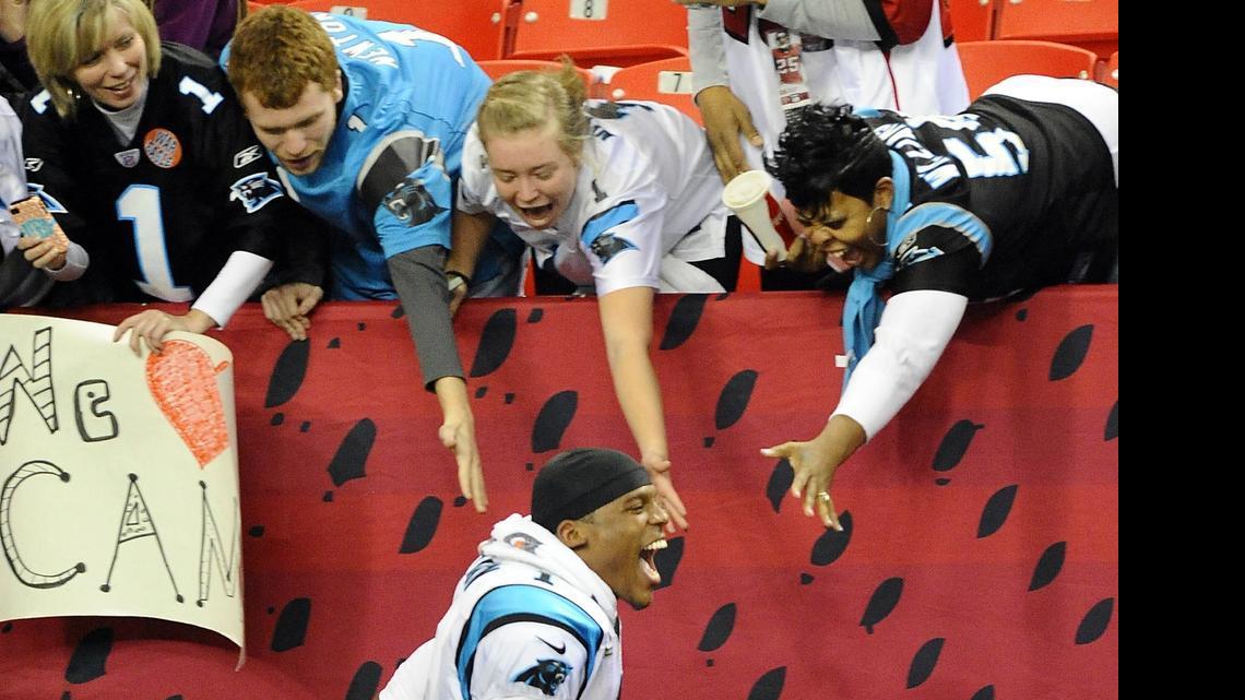 
Carolina Panthers quarterback Cam Newton (1) runs and cheers with Panthers fans along the sideline wall after defeating the host Atlanta Falcons at the Georgia Dome on Dec. 29, 2013.  Monday, the Panthers fan group Roaring Riot will announce seven new chapters across the country that will assemble every Sunday the Panthers play.
