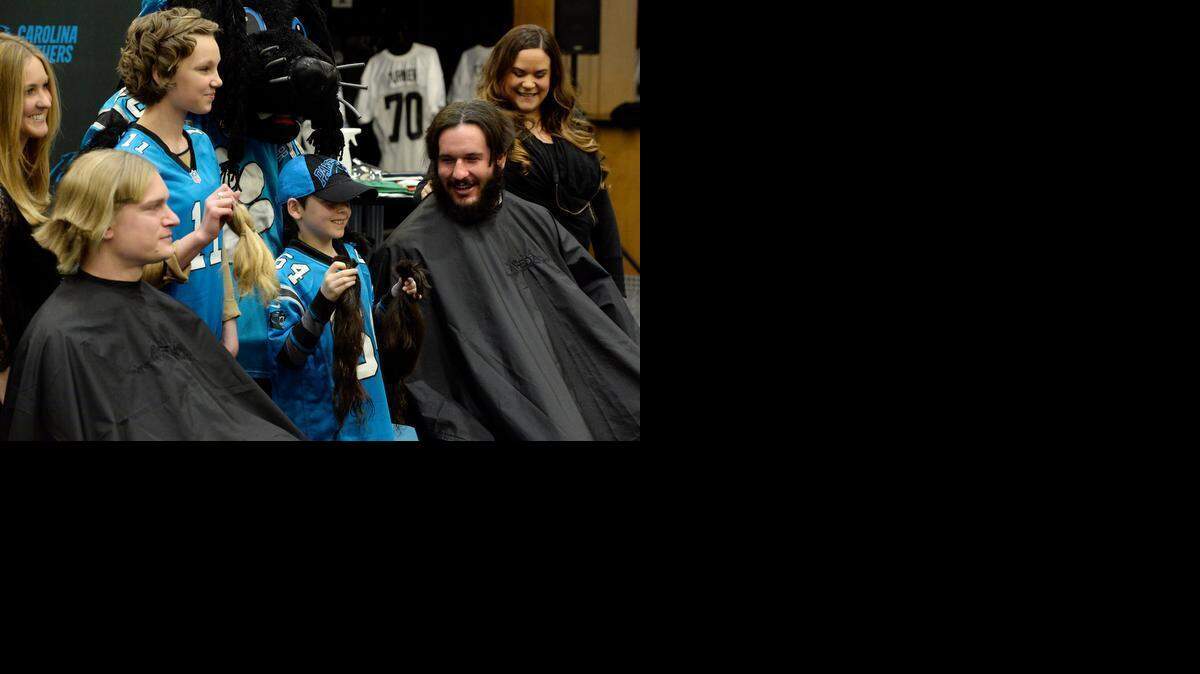 
Wesley Thornburg, center left, 17, a two-time leukemia survivor, smiles as she holds up a section of Carolina Panthers’ Brenton Bersin’s blond hair, and oncology patient Jeramiah Karriker, center right, 9, holds up a section of Brian Folkerts’ brown hair in the Carolina Panthers locker room. The two players made a hair donation toWigs for Kids on Wednesday.
