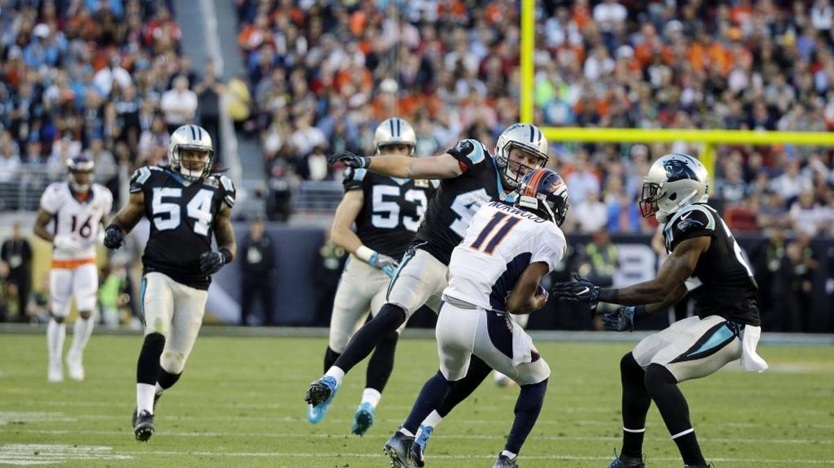 Carolina Panthers defenders, including gunner Teddy Williams (21) surround Denver Broncos return man Jordan Norwood (11), who didn’t call a fair catch as they assumed and took the punt back 61 yards, the longest return in Super Bowl history.