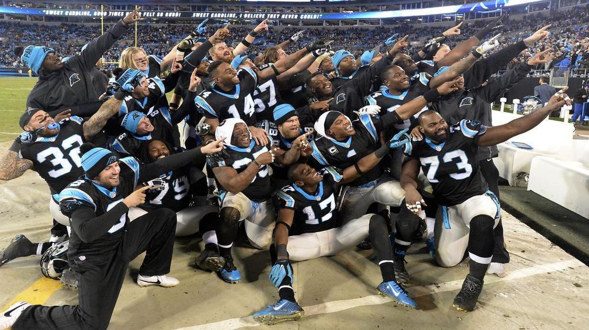 Members of the Carolina Panthers point to the stands as they pose for a photo while celebrating their impending victory over the Tampa Bay Buccaneers late in the fourth quarter at Bank of America Stadium on Sunday, January 3, 2016. The Panthers won 38-10, and secured home field through the playoffs.