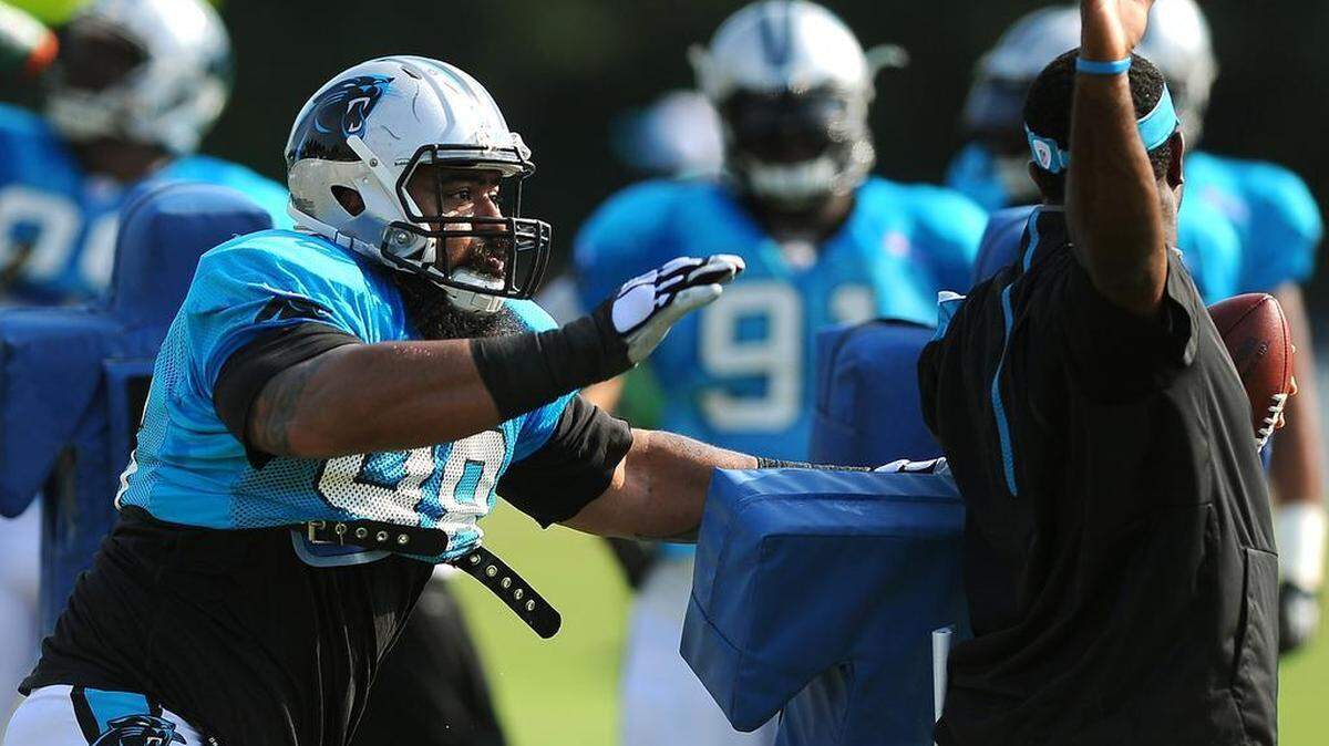 
Carolina Panthers Star Lotulelei, left, makes a swipe at a ball held by Sam Mills III, right, during practice on Monday. Lotulelei later left practice with what head coach Ron Rivera described as soreness in his surgically repaired right foot. 
