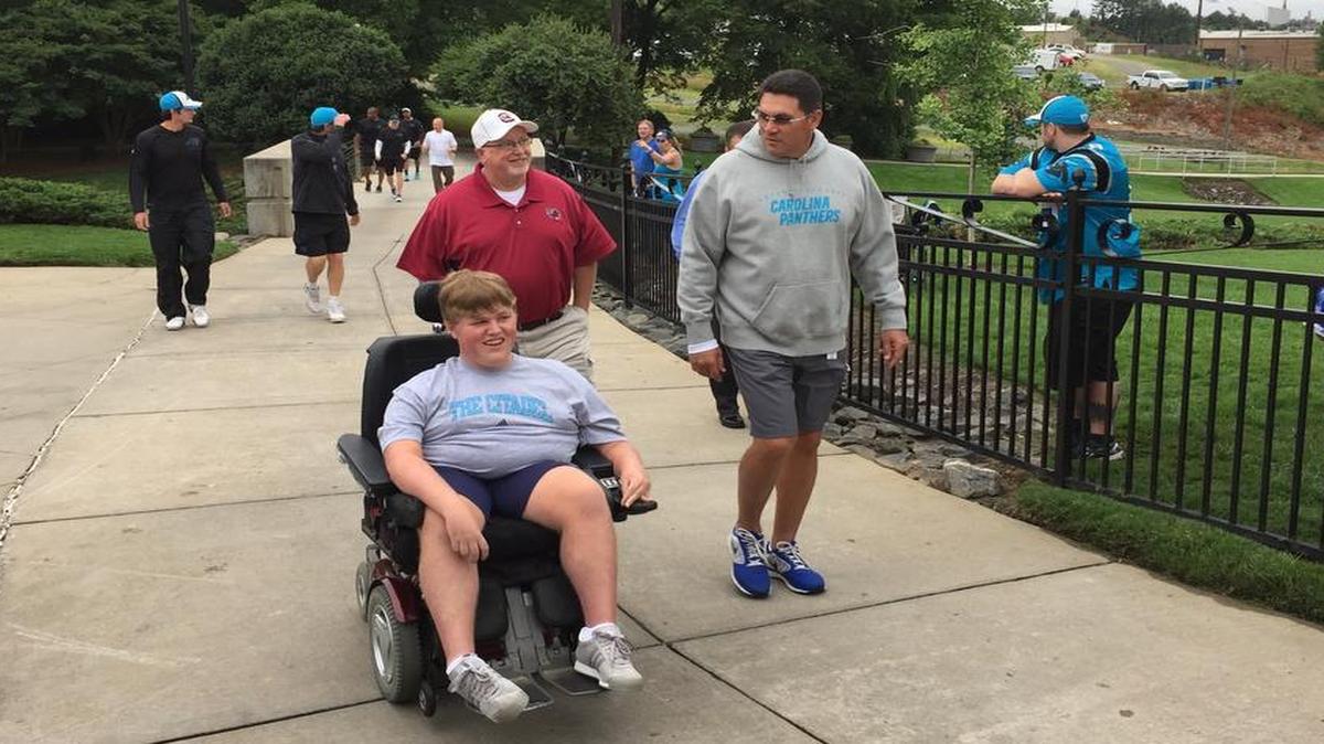 
Panthers coach Ron Rivera, right, invites Seth Myers, in town for a doctor’s appointment, and his father, Douglas, to the team’s practice Thursday. 

