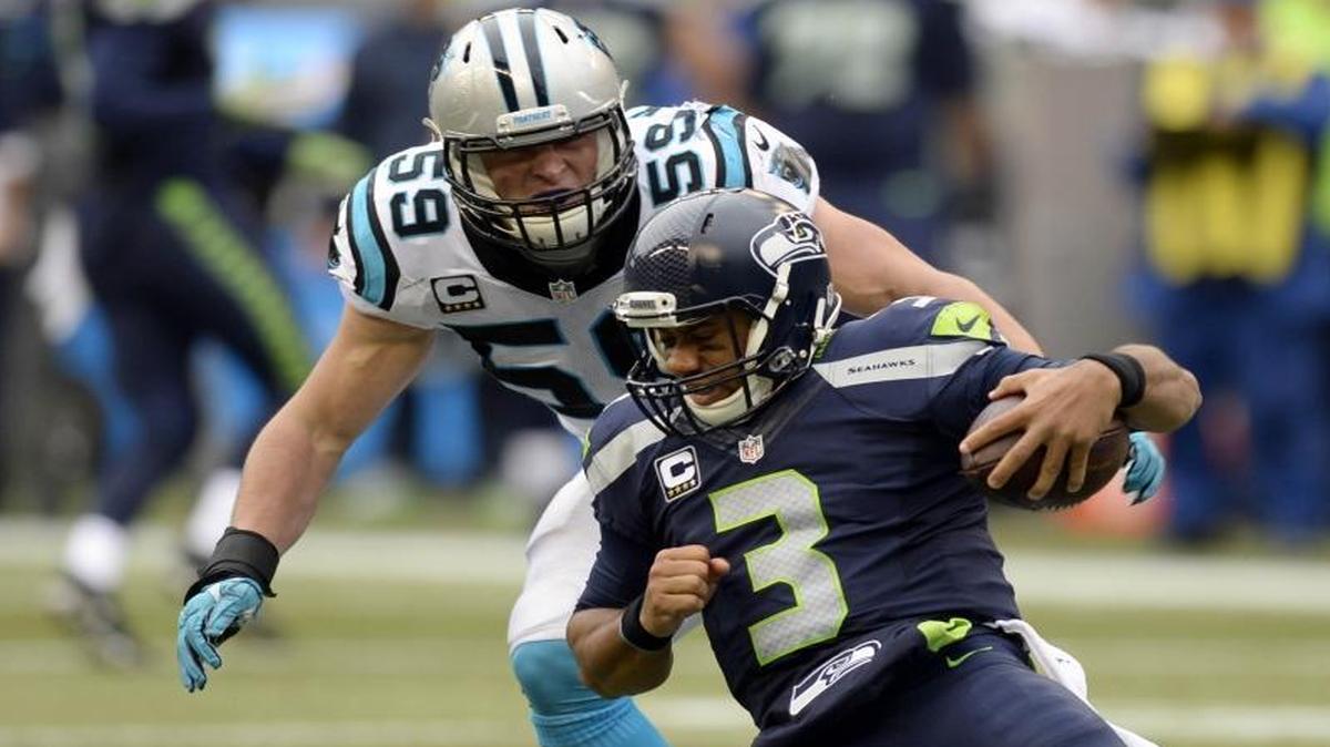
Seattle Seahawks quarterback Russell Wilson slides as Carolina Panthers linebacker Luke Kuechly (59) closes in.


