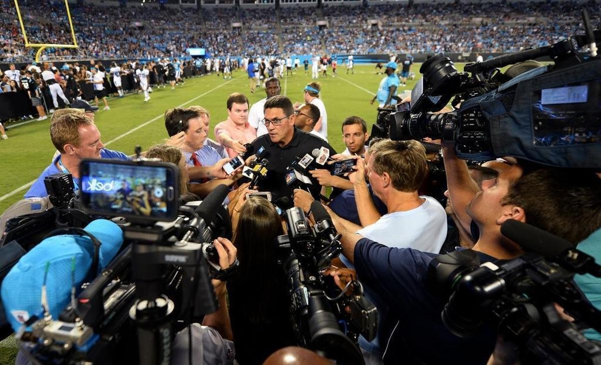 Carolina Panthers head coach Ron Rivera is surrounded by media following Friday’s practice at Fan Fest at Bank of America Stadium in Charlotte.