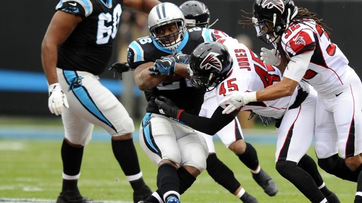 Carolina Panthers running back Jonathan Stewart (28) spins while trying to pick up yards as Atlanta Falcons middle linebacker Deion Jones (45) reaches for the ball Saturday. The Falcons won 33-16.