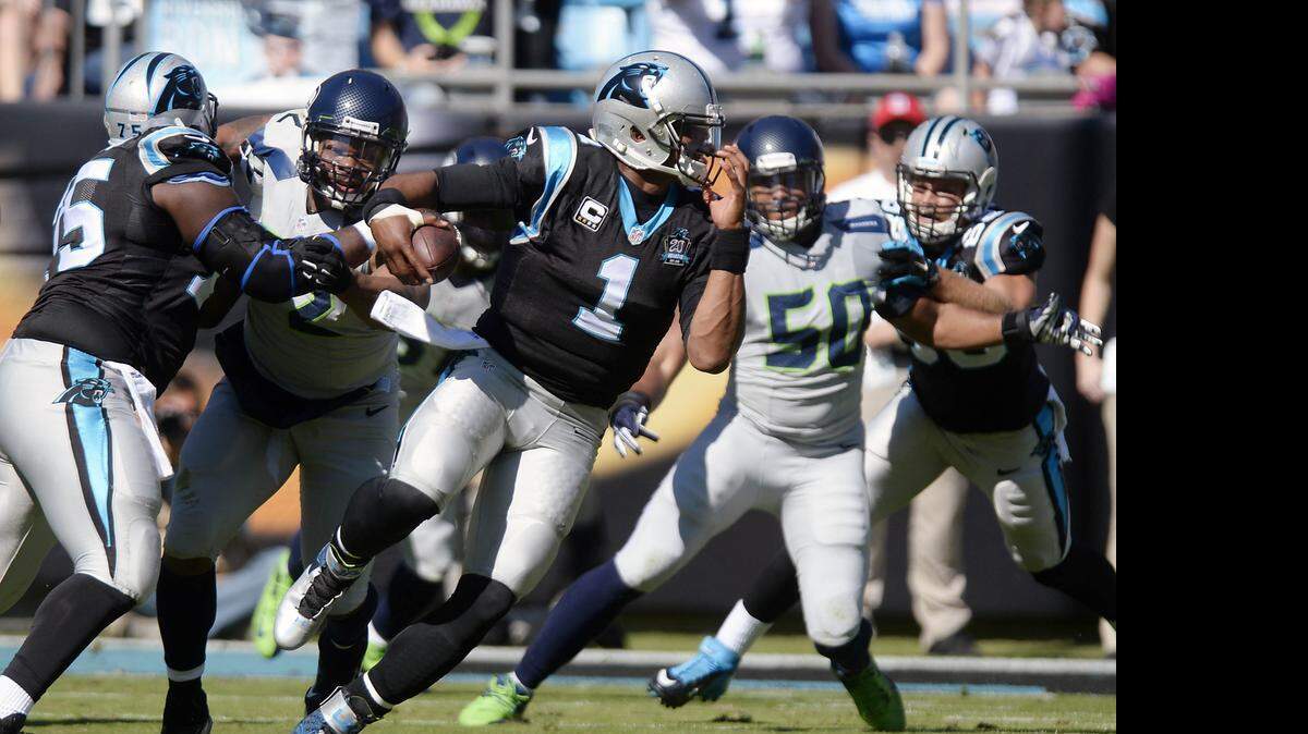 
Carolina Panthers' Cam Newton (1) looks to avoid Seattle Seahawks defenders  at Bank of America Stadium on Sunday, October 26, 2014. The Panther will face the Seahawks in week 6 in Seattle.

