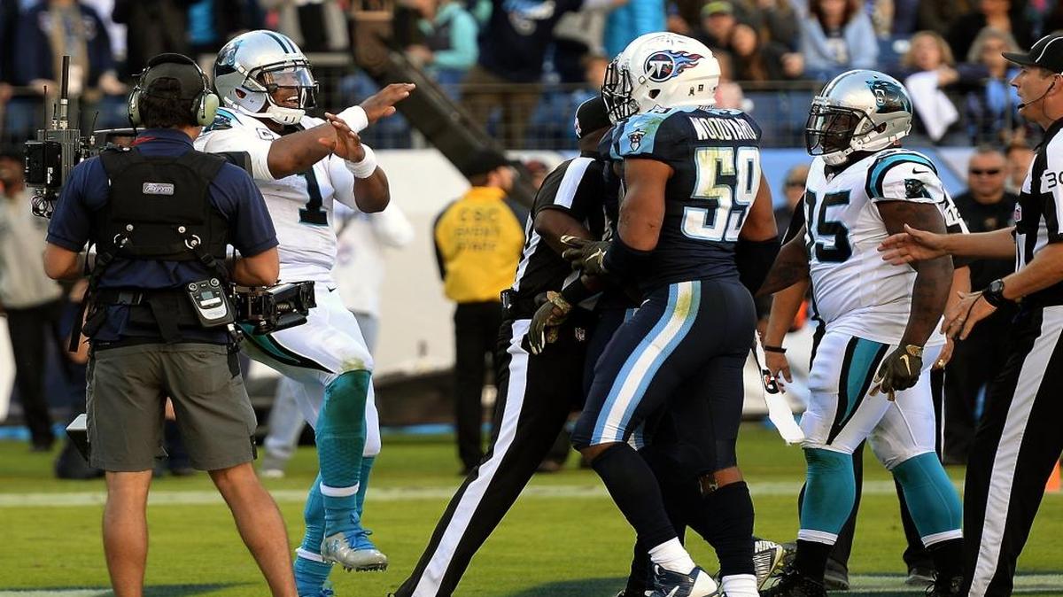 Carolina Panthers quarterback Cam Newton, left, does a dance move called “hittin’ dem folks” as he celebrates his touchdown run in the fourth quarter against the Tennessee Titans. Linebacker Wesley Woodyard, center, took offense.
