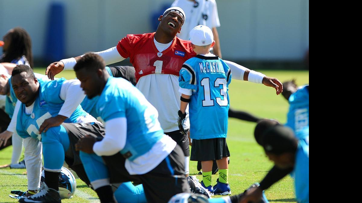 
Carolina Panthers quarterback Cam Newton stretches out his arms and reacts as he talks with Matthew McCaskill, 7, of Fort Bragg, during the team's minicamp practice on Wednesday, June 17, 2015. McCaskill visited the Panthers as part of the Make-A-Wish program. During the practice McCaskill wore gloves and caught passes while being escorted by his favorite player, wide receiver Kelvin Benjamin. 
